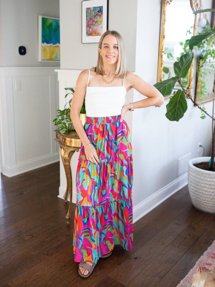 woman wearing resort wear look consisting of a white tank and colorful maxi skirt