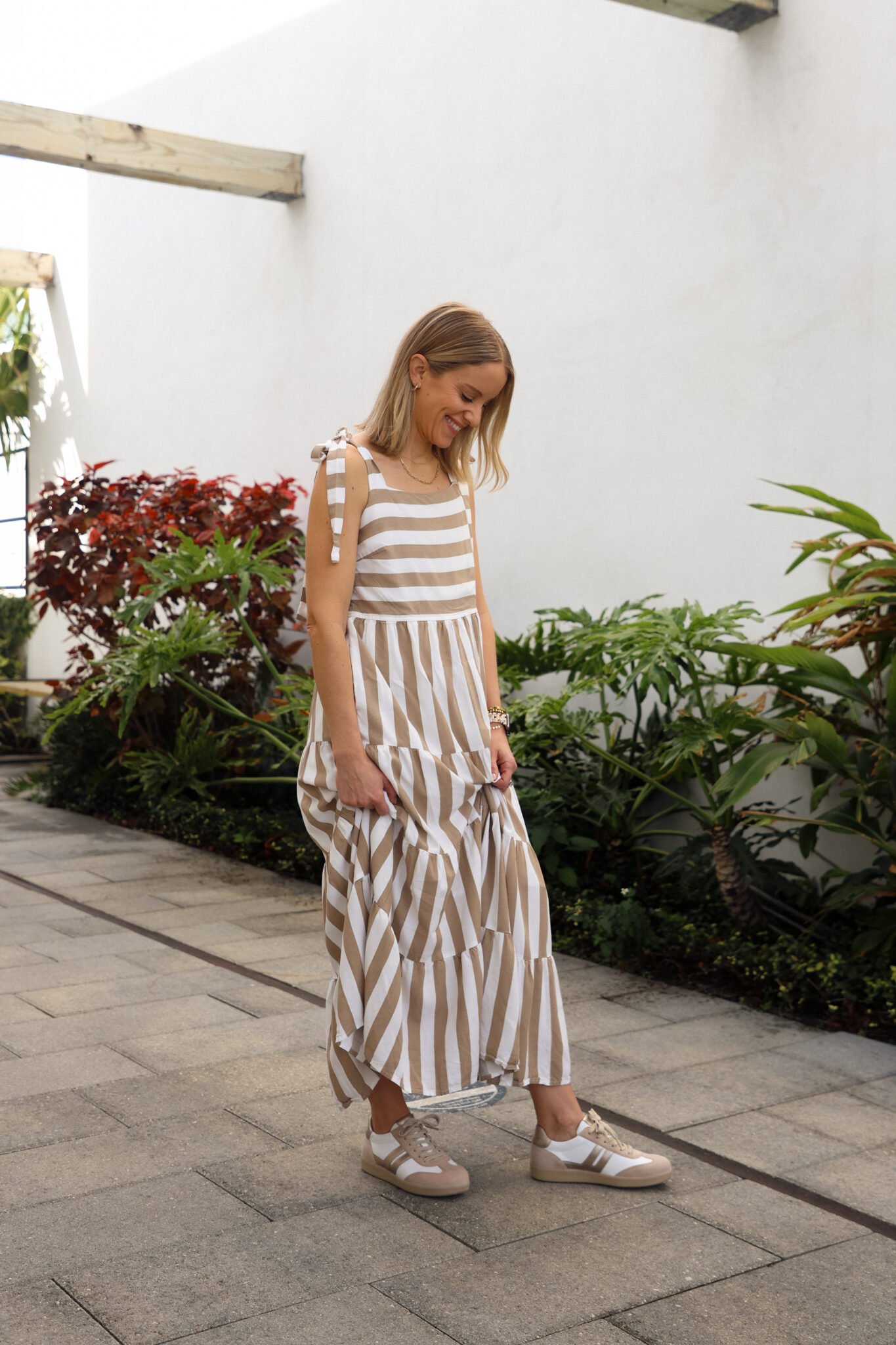 woman wearing striped maxi dress and sneakers