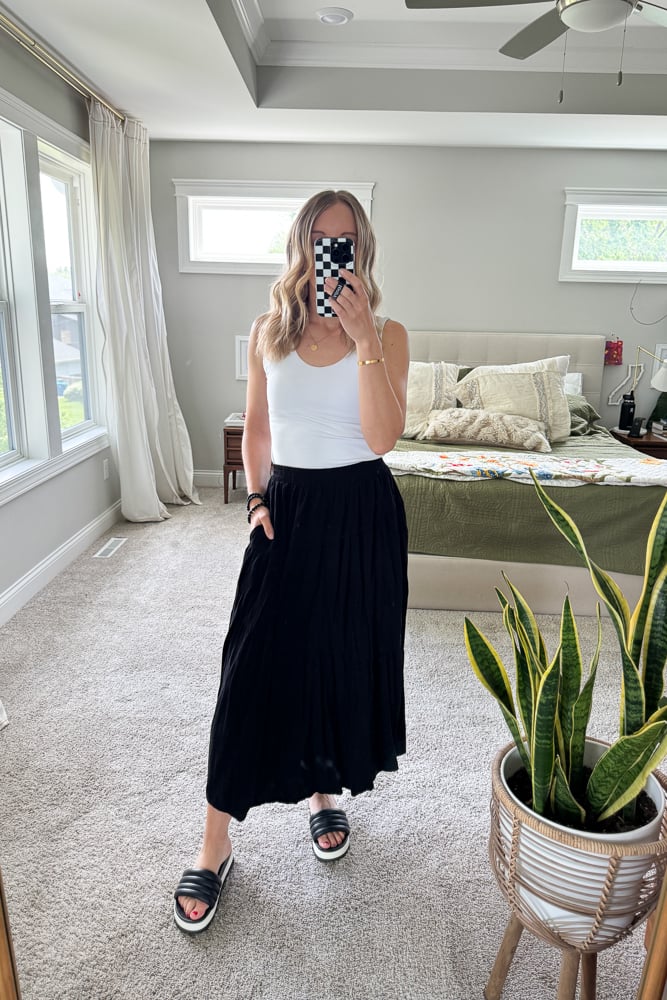 Woman in white tank and black maxi skirt
