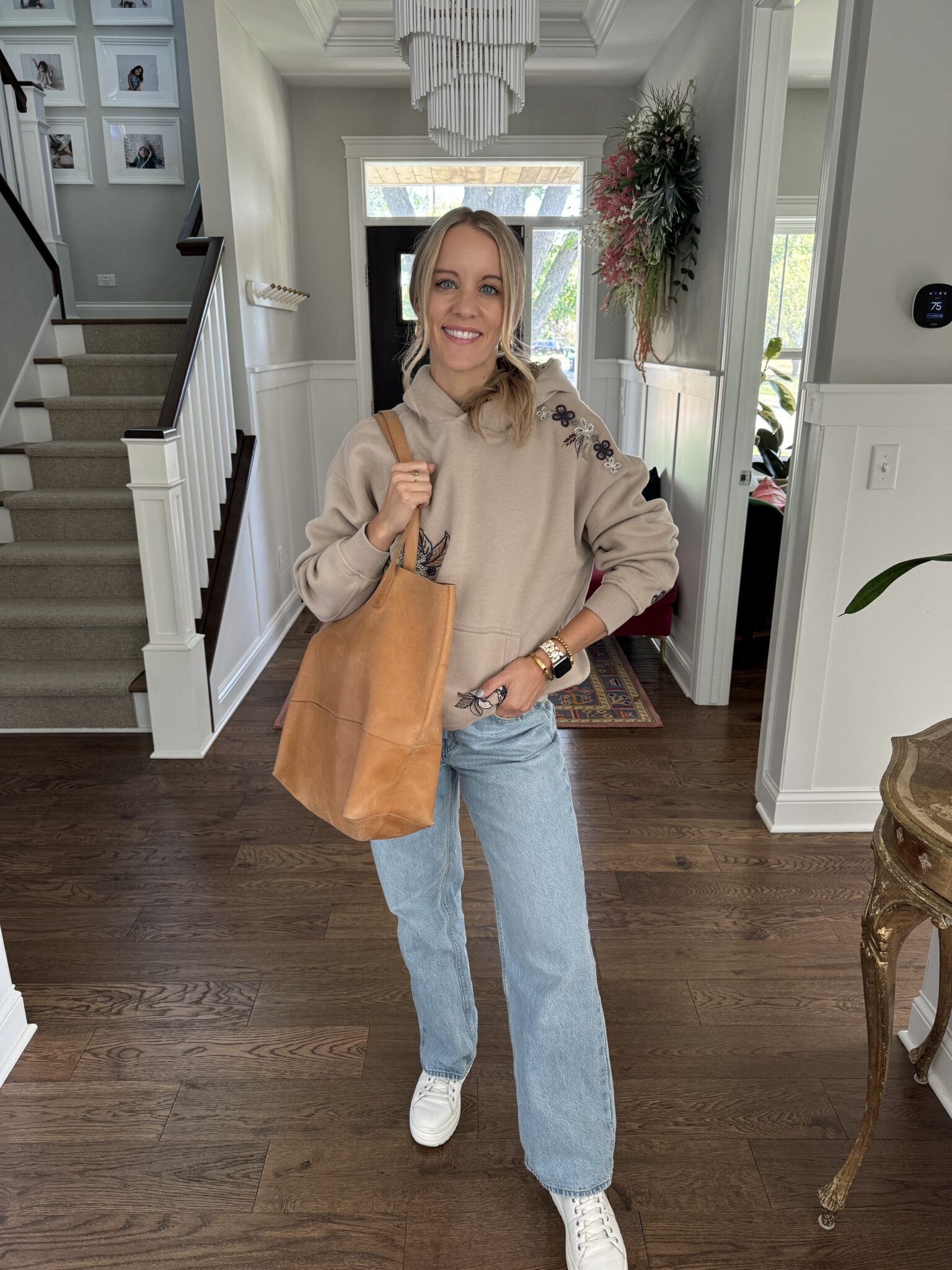 woman wearing a casual out with a leather tote bag.