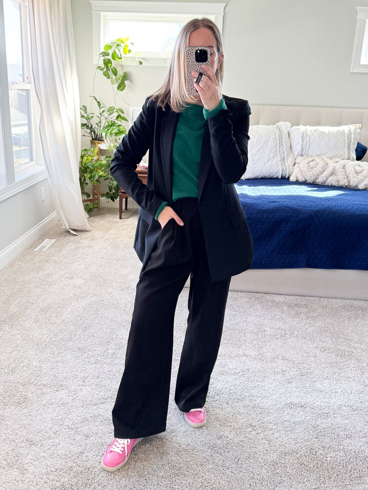 woman wearing a green sweater with black blazer set and pink sneakers