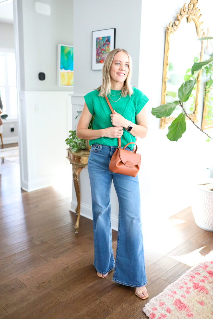 Woman wearing bell bottoms with green top.