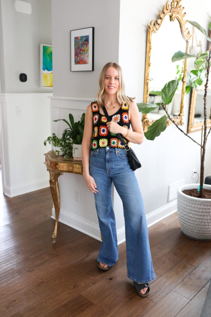 Woman wearing bell bottoms with crocheted tank top.