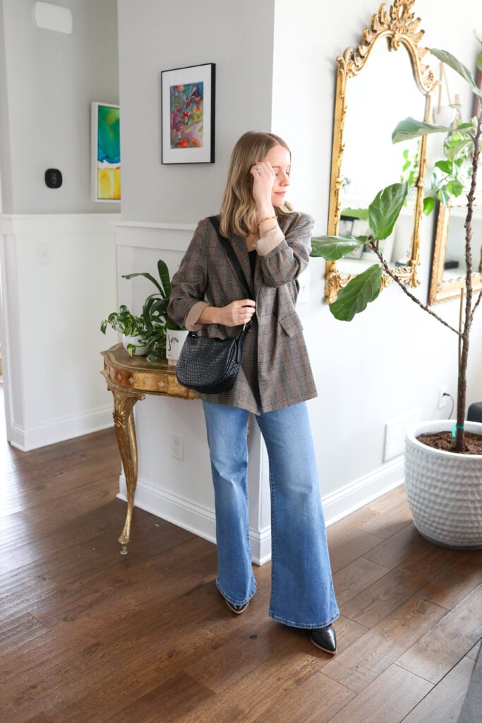 Woman wearing bell bottoms with blazer and heeled boots.