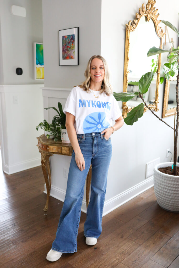 Woman wearing bell bottoms with graphic tee.