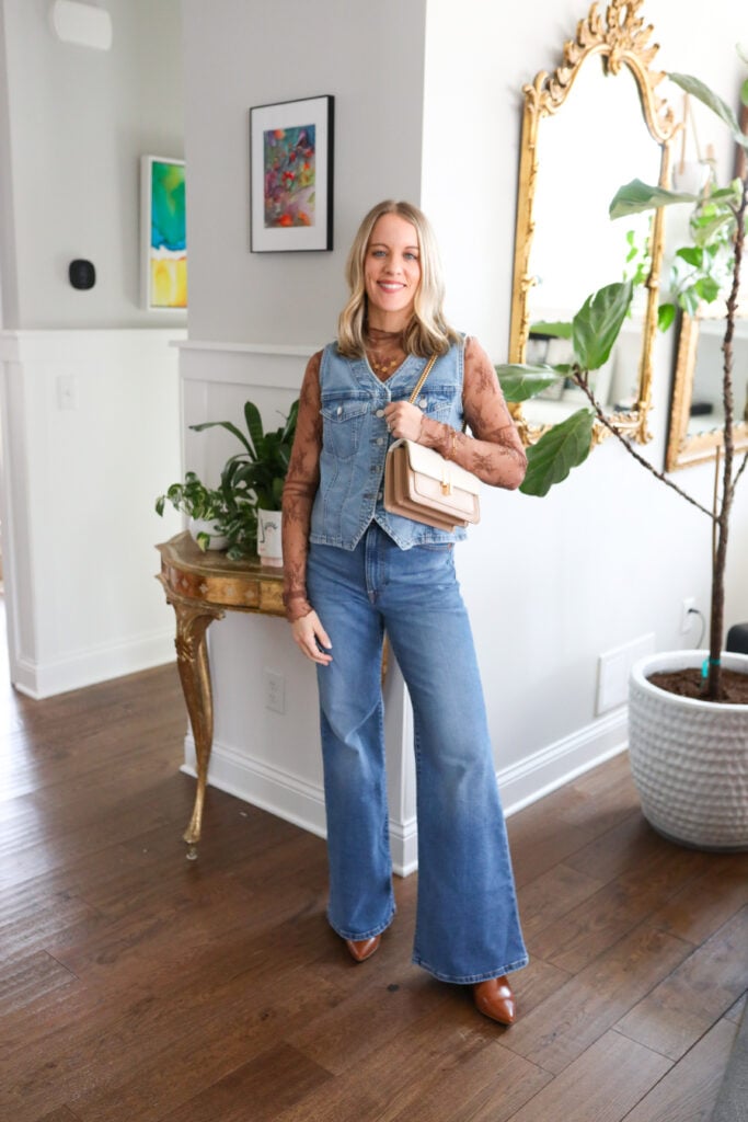 Woman wearing bell bottoms with lace top and denim vest.