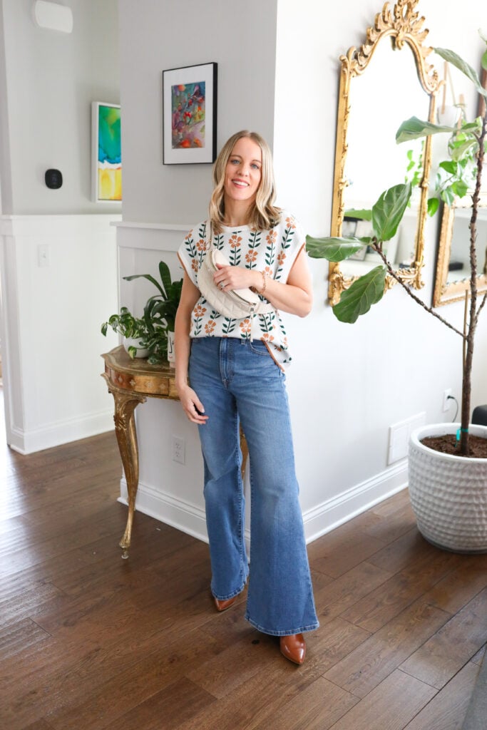 Woman wearing bell bottoms and sweater tank.