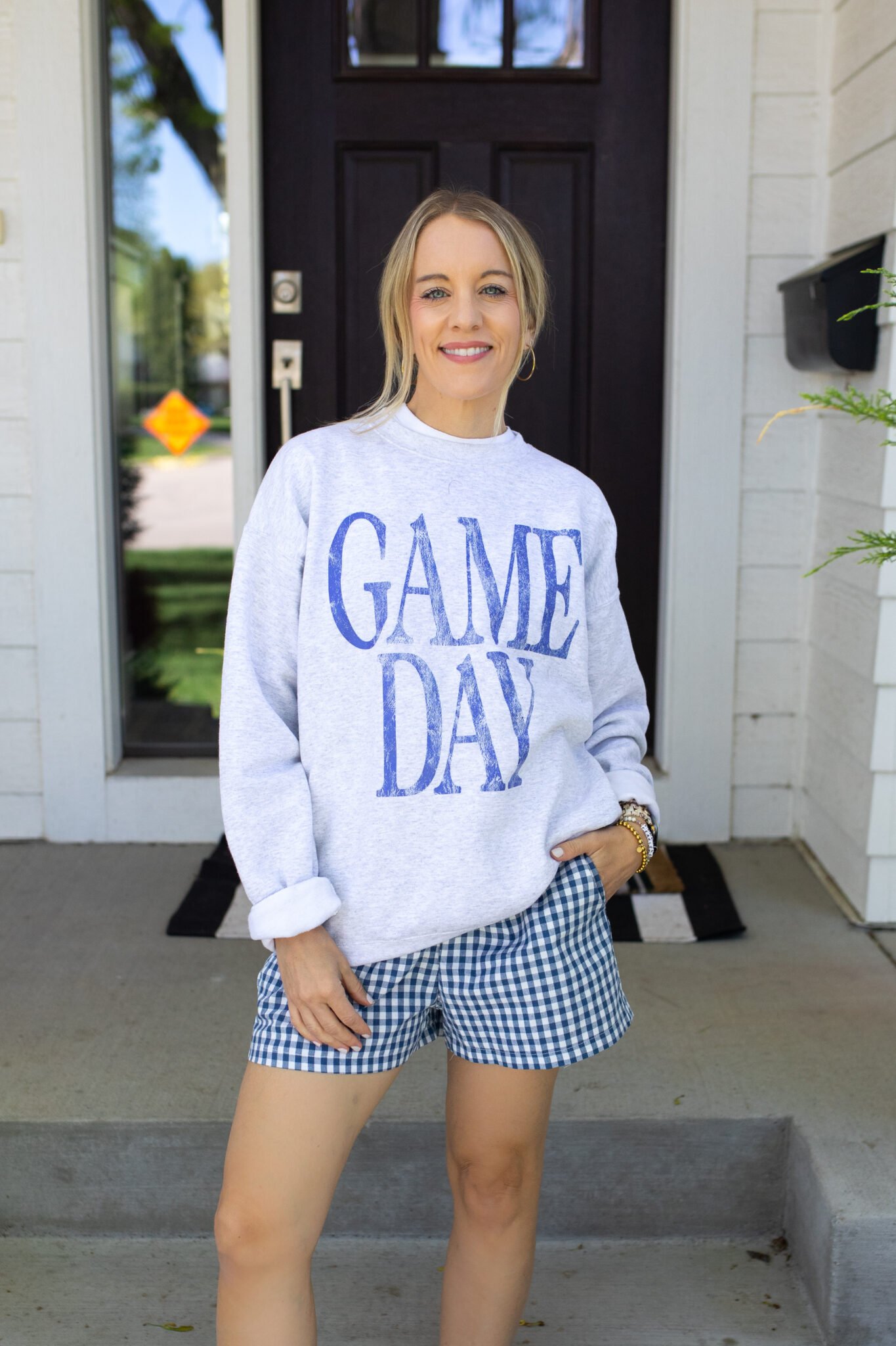 Gingham boxer shorts styled with a simple sweatshirt and minimal accessories for an easy summer look.
