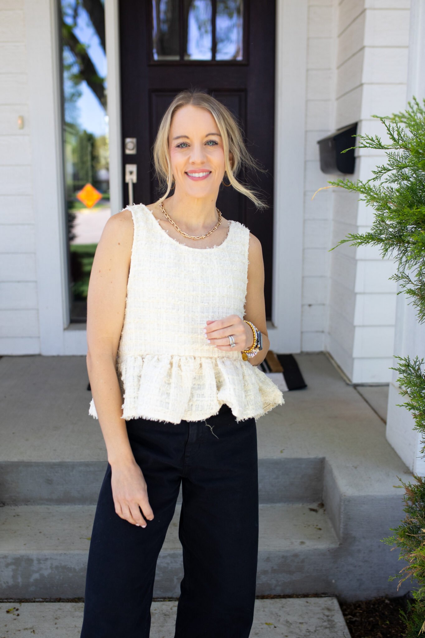 Cream ruffle peplum top styled with black denim jeans for a trendy, wearable look.