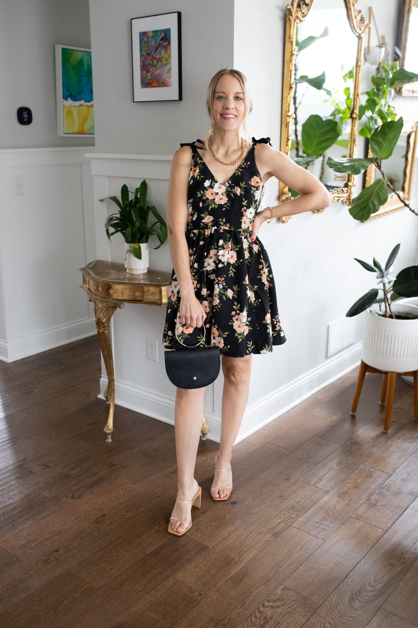 Black floral mini dress with deep V-neck and tie-shoulder straps, perfect for a casual wedding or cocktail party.