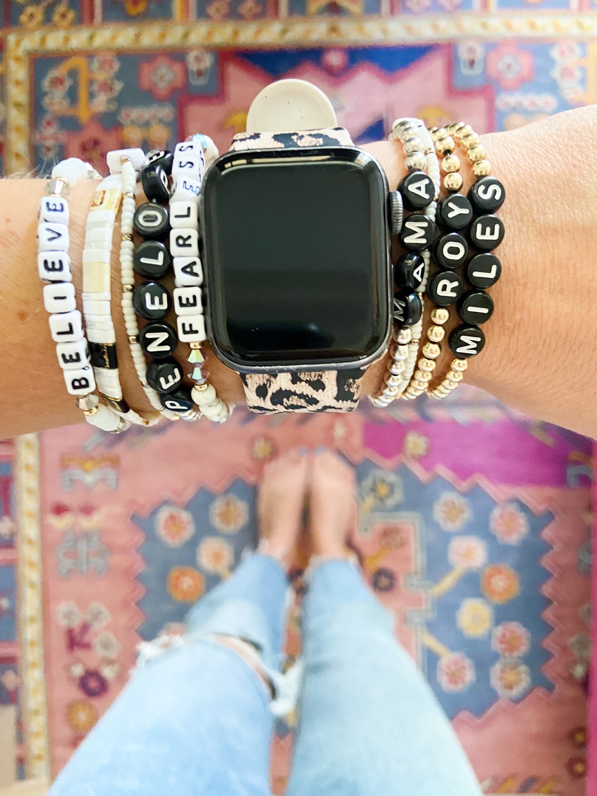 Close-up of a leopard print Apple Watch band styled with casual outfit, showing the soft silicone material and bold pattern.