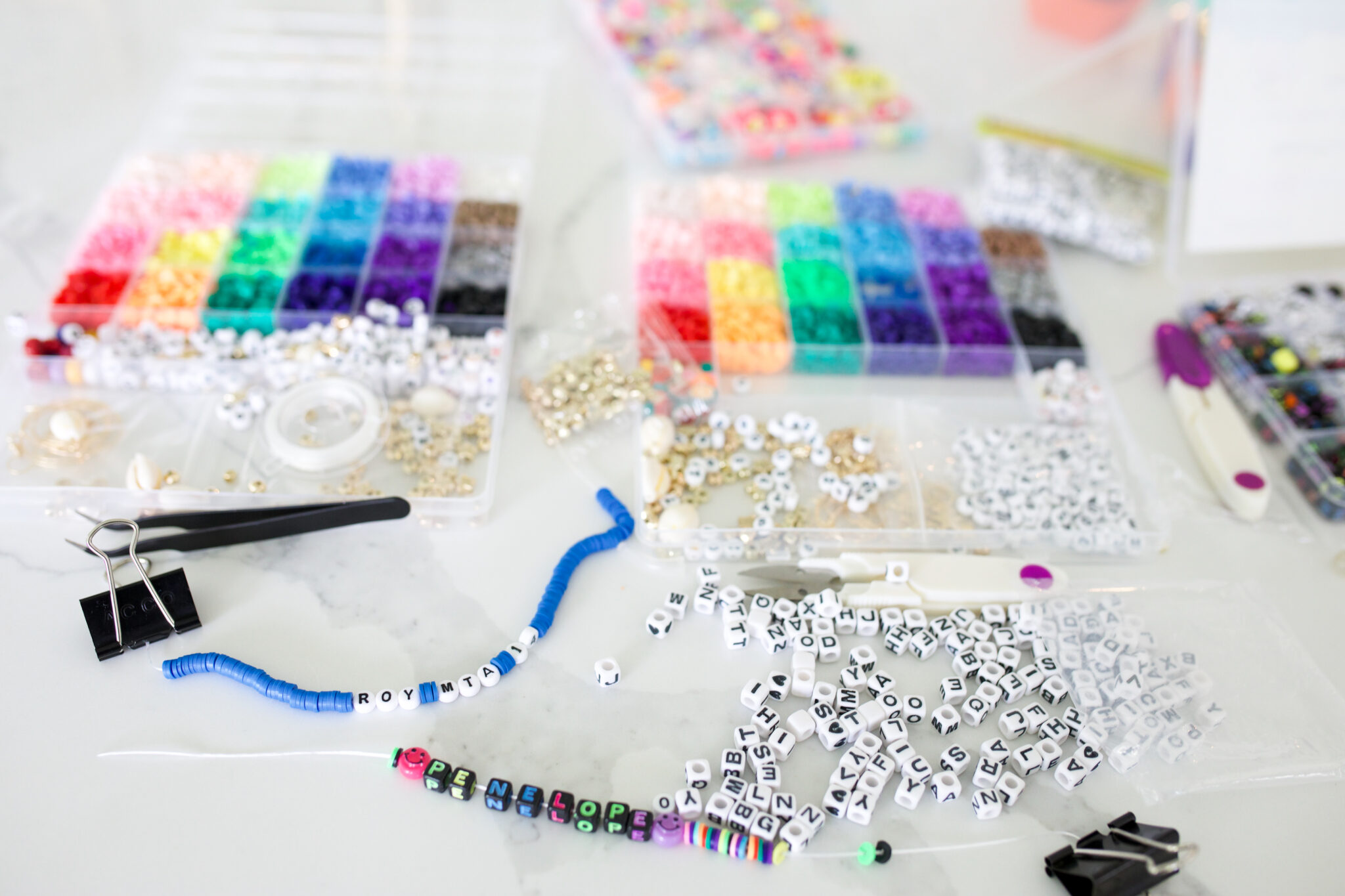 Colorful rubber bands from the Rainbow Loom Mega Combo Set spread out with completed bracelets.