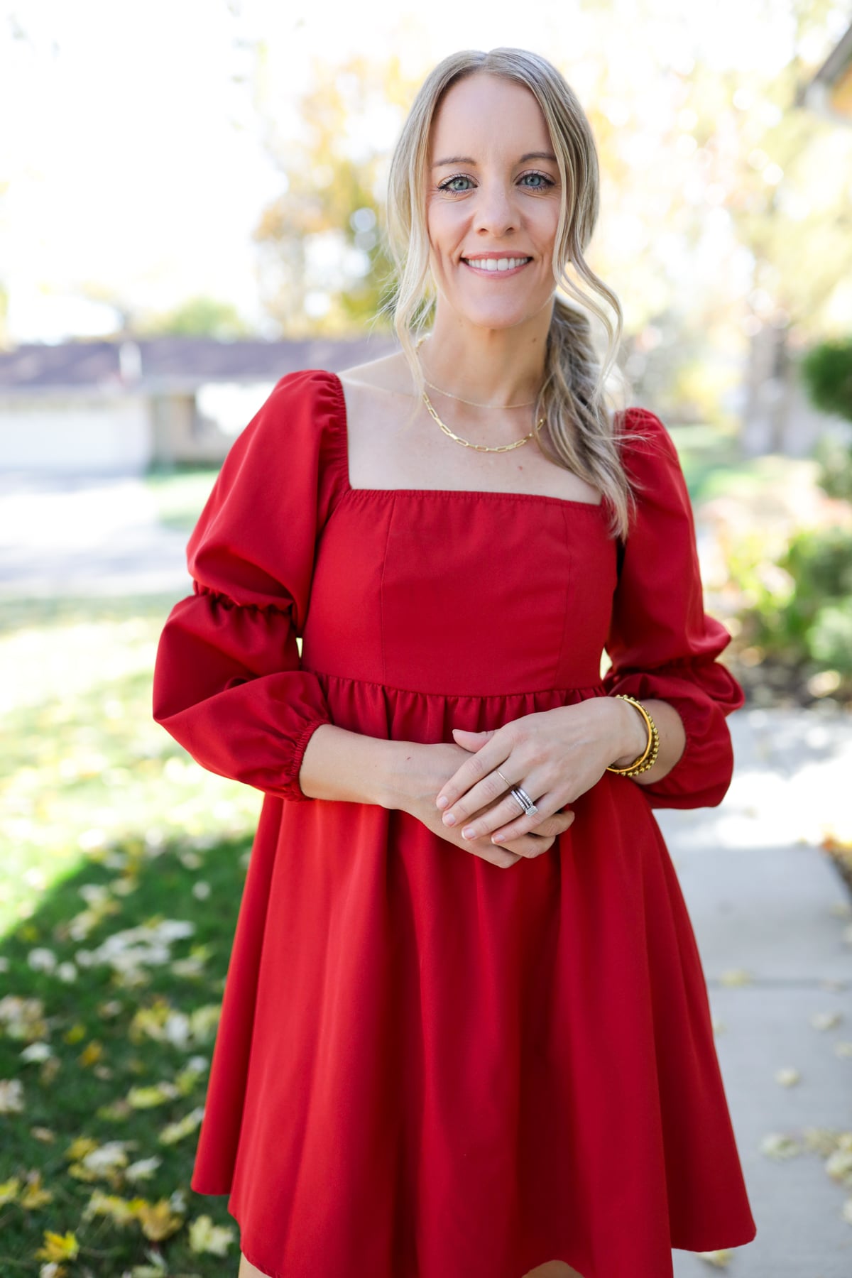 Jen wearing a dainty gold paperclip chain necklace with a red dress, styled for an easy, everyday look.