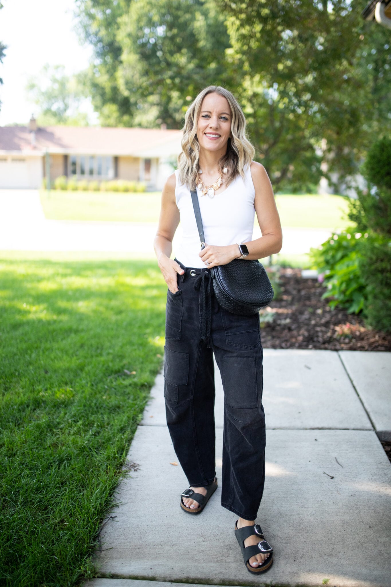 Patchwork barrel jeans styled with a white tank, sandals, and black bag for a casual summer look.