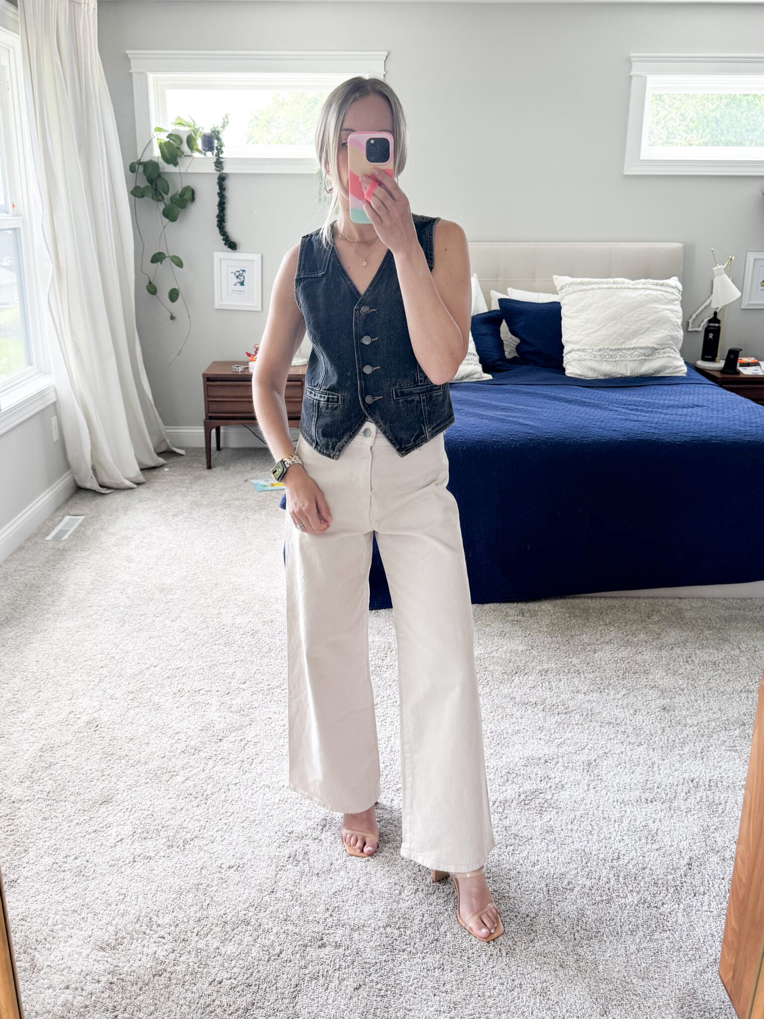 Styling wide leg jeans with a denim vest and clear heels for an elevated casual look.