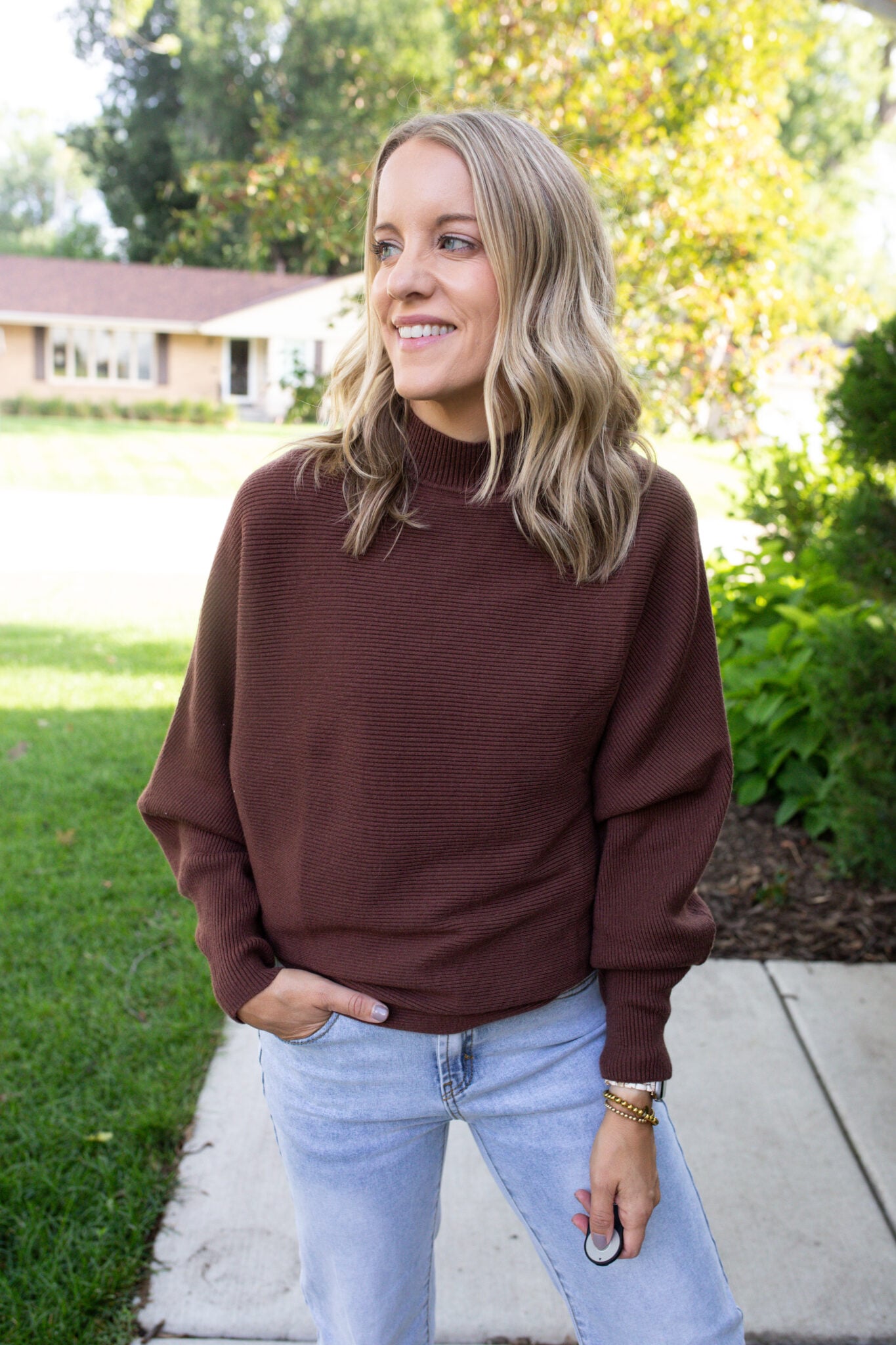 Jen Paisley of Paisley and Sparrow styled in a cozy fall fashion outfit with a brown funnel neck sweater from Amazon, paired with light wash jeans for an effortless everyday look.