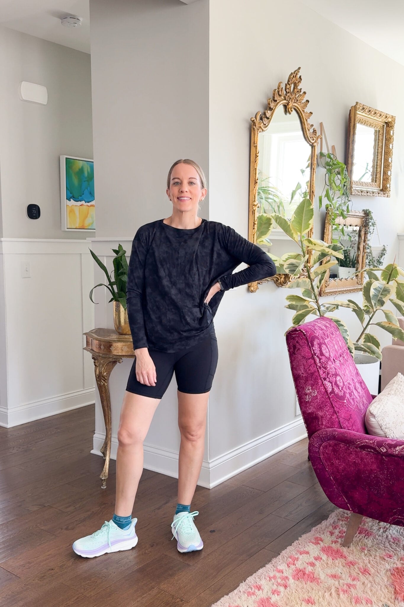 Mirror selfie of Jen in a red CRZ Yoga ribbed tank top and high-rise black Sunzel leggings. Holding a red water bottle post-workout in a locker room setting.