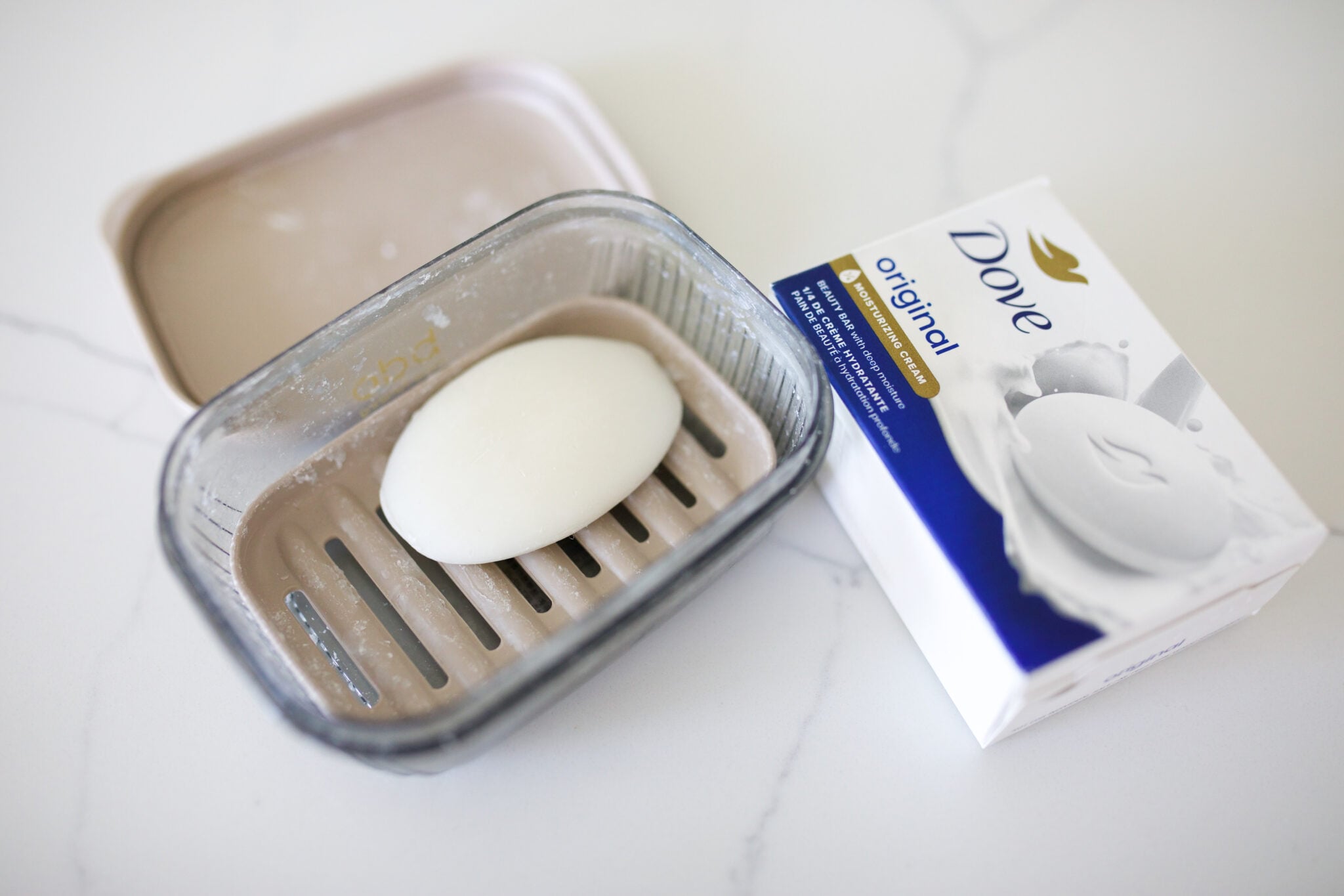 Dove soap bar in a beige travel case with box packaging beside it
