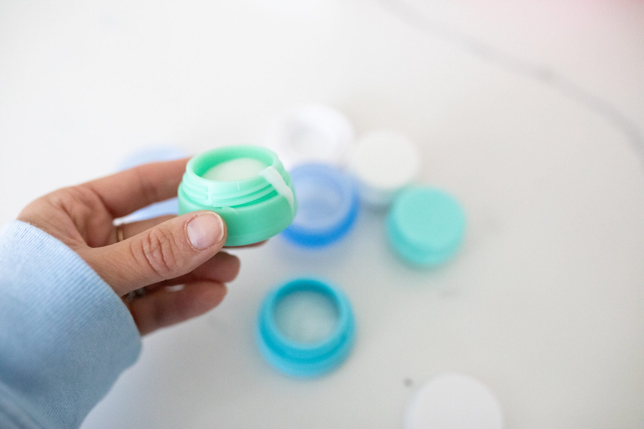 Small refillable travel containers in pastel colors with lotion inside