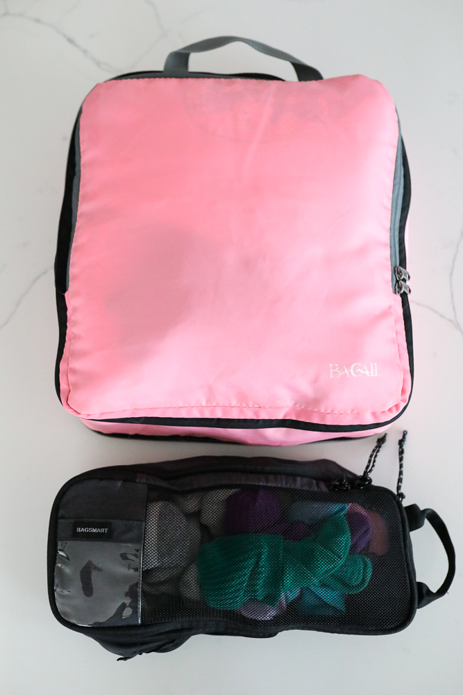 Pink and black packing cubes for organizing clothes and accessories