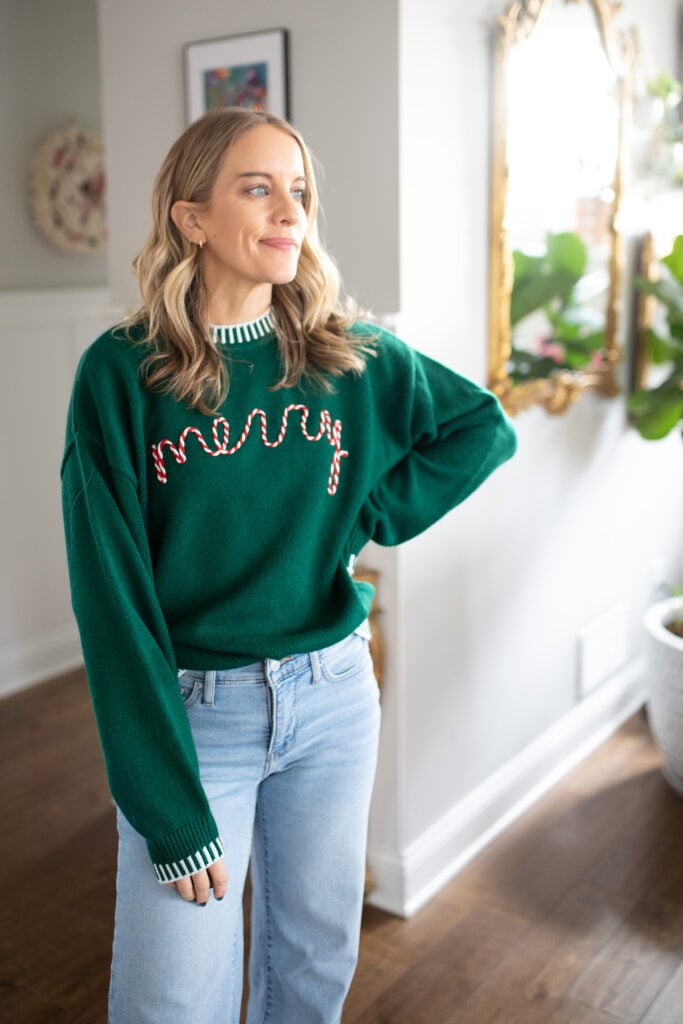 Green Christmas sweater with the word "merry" in red and white